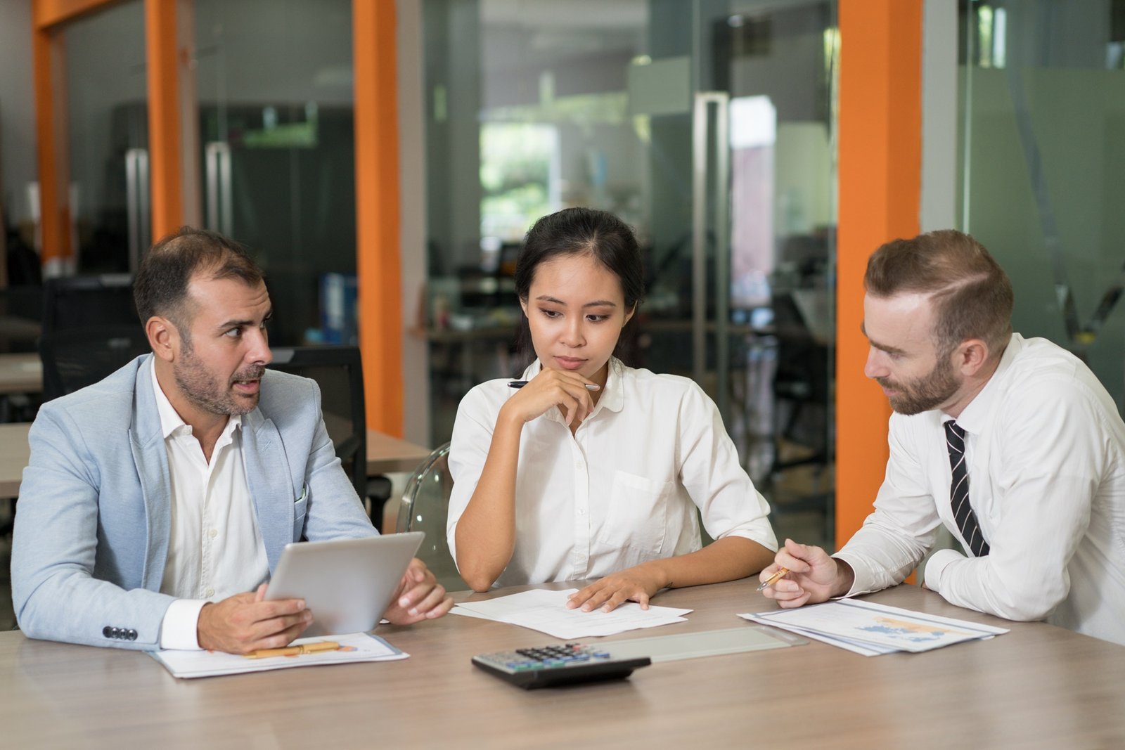 Three thoughtful marketing analysts working with diagrams